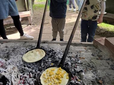 Børn der laver mad over bål 